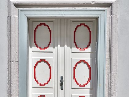weiße Tür mit roten Verzierungen