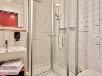 Blick ins Duschbad mit Duschkabine und Waschbecken