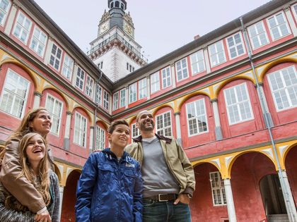 Eine Familie steht im Innenhof des Wolfenbütteler Schlosses